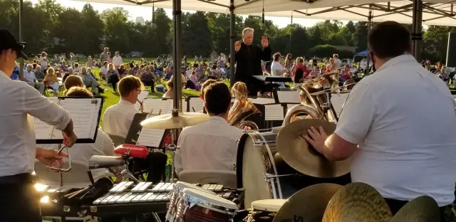 The conductor leading the band at Cranmer Park